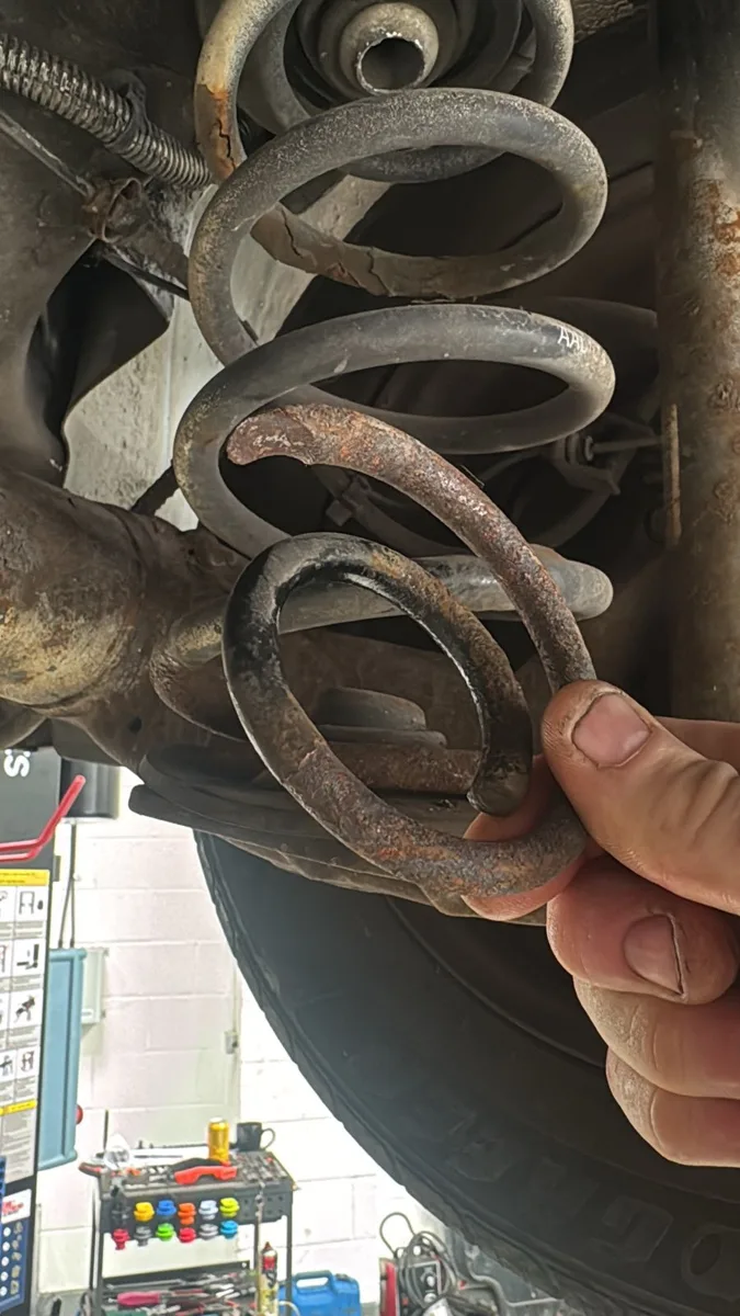 Broken coil spring held in a hand