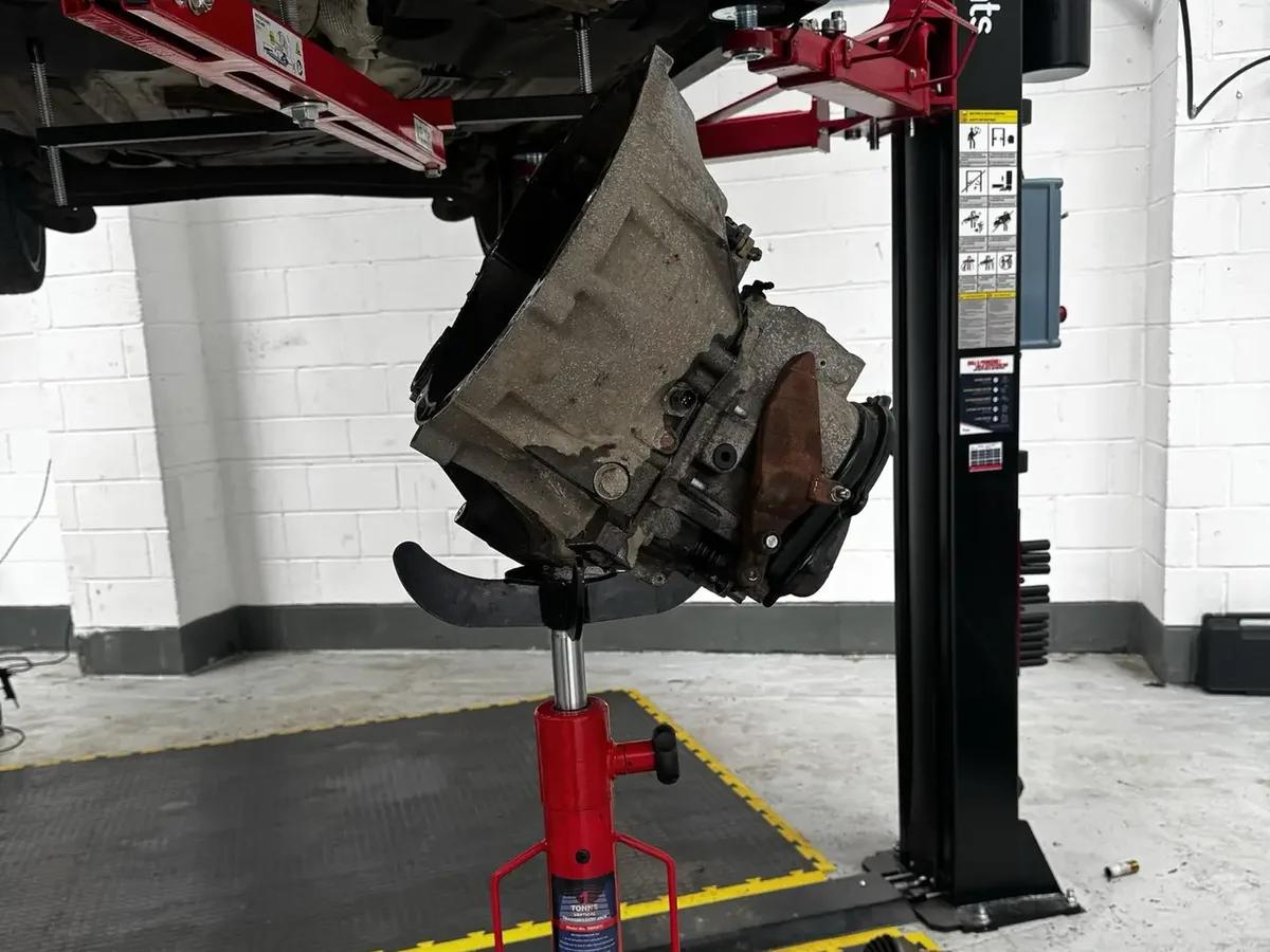 Ford Fiesta gearbox lowered on a transmission jack during removal