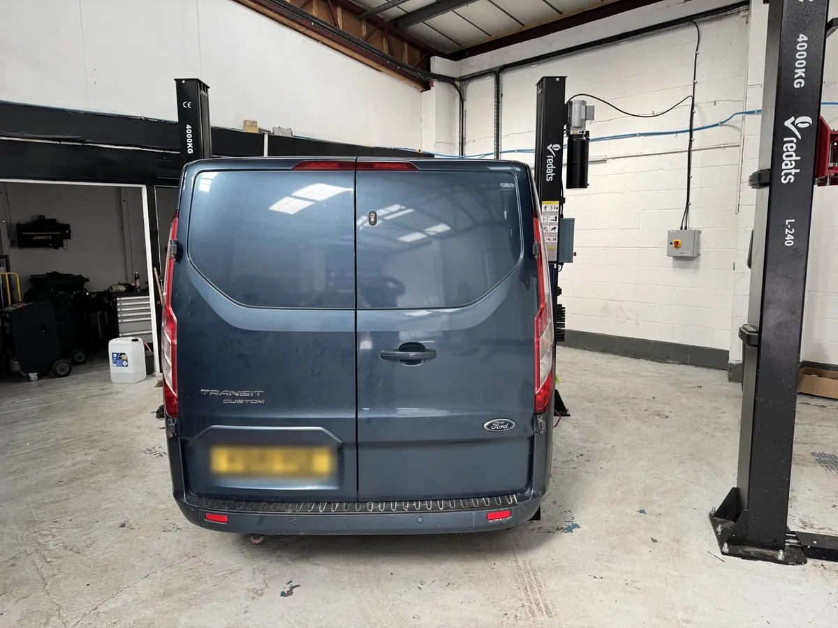 Ford Transit Custom between the two-post lifts at Enviro Repair's Royston workshop