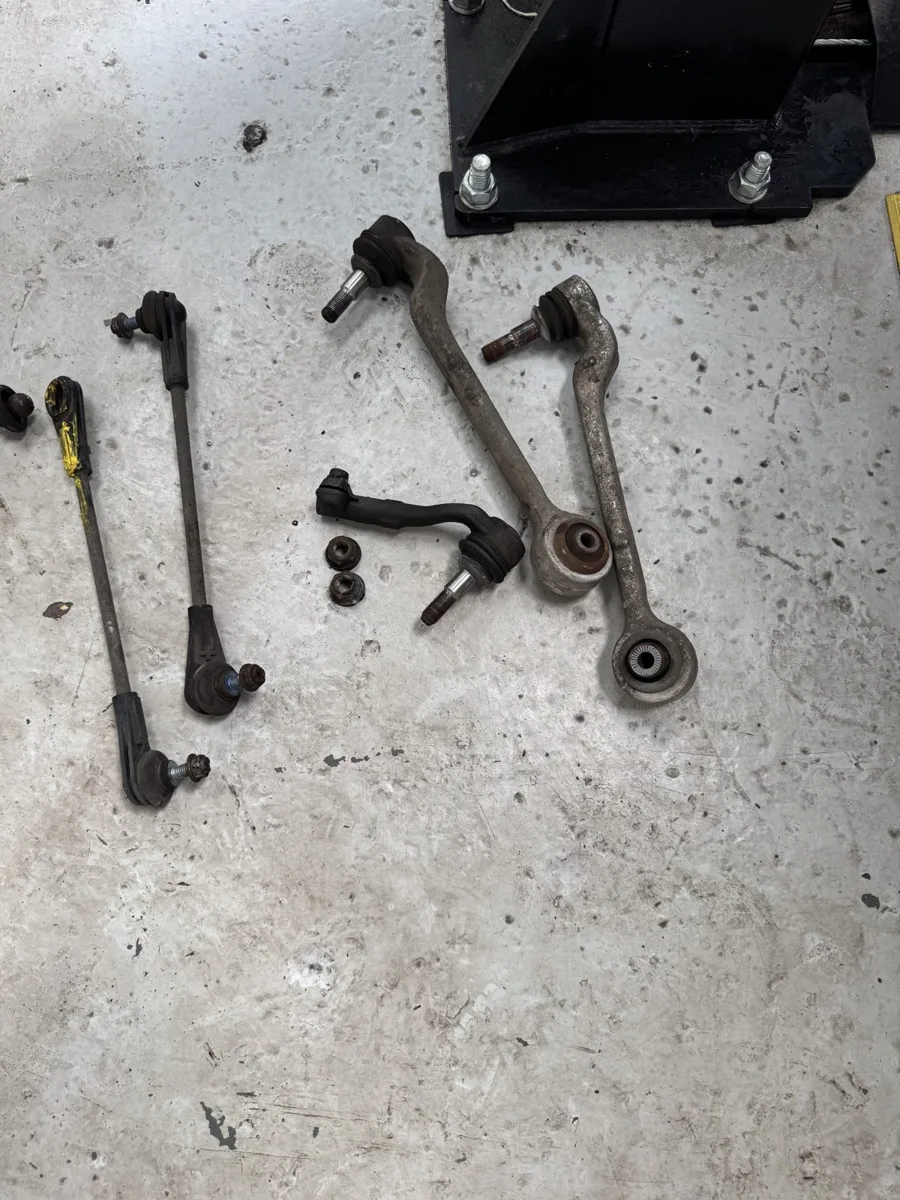 Front suspension control arms and drop links laid out after removal