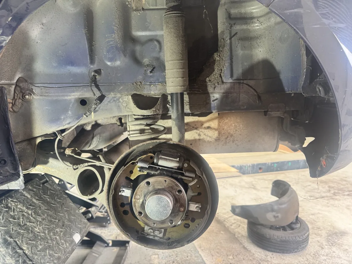 Rear drum brake assembly with the drum removed, showing the shoes and springs