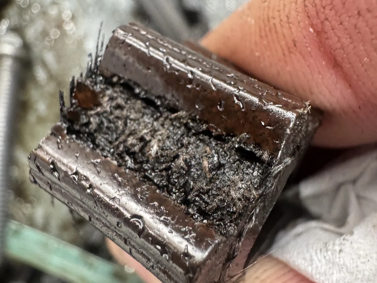 Degraded wet belt with delaminating teeth and exposed fibres